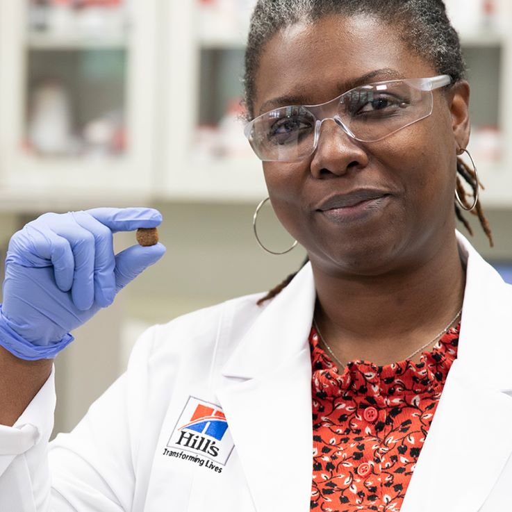 дослідник Hill's Pet Nutrition тримає в руці корм Hill's Pet